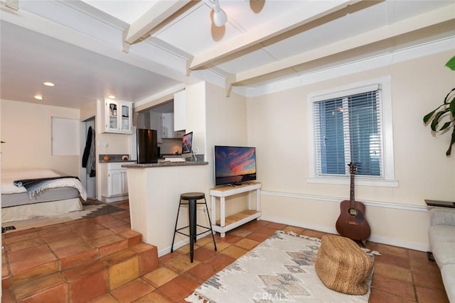 living room with beamed ceiling and tile patterned floors