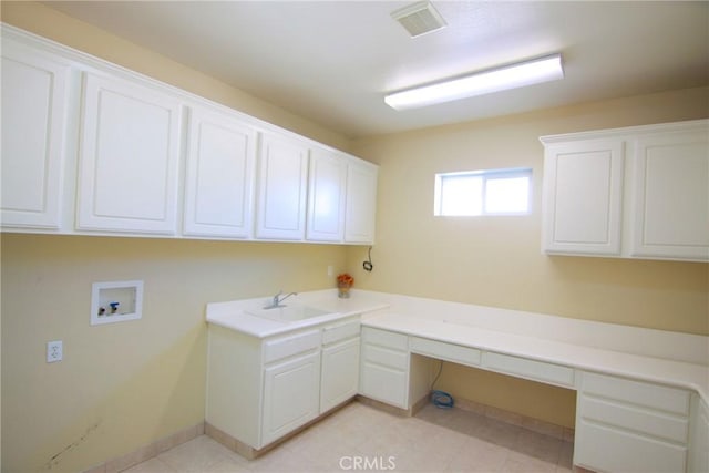 laundry room featuring cabinets, light tile patterned flooring, hookup for a washing machine, and sink