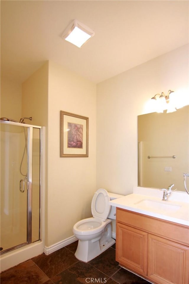 bathroom with vanity, a shower with shower door, and toilet