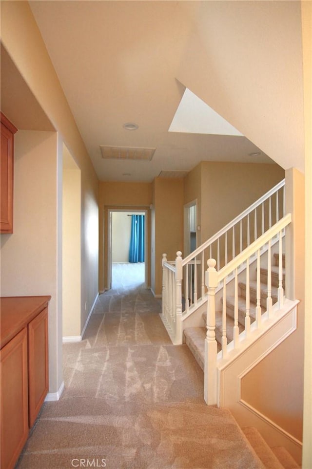 hallway featuring light colored carpet