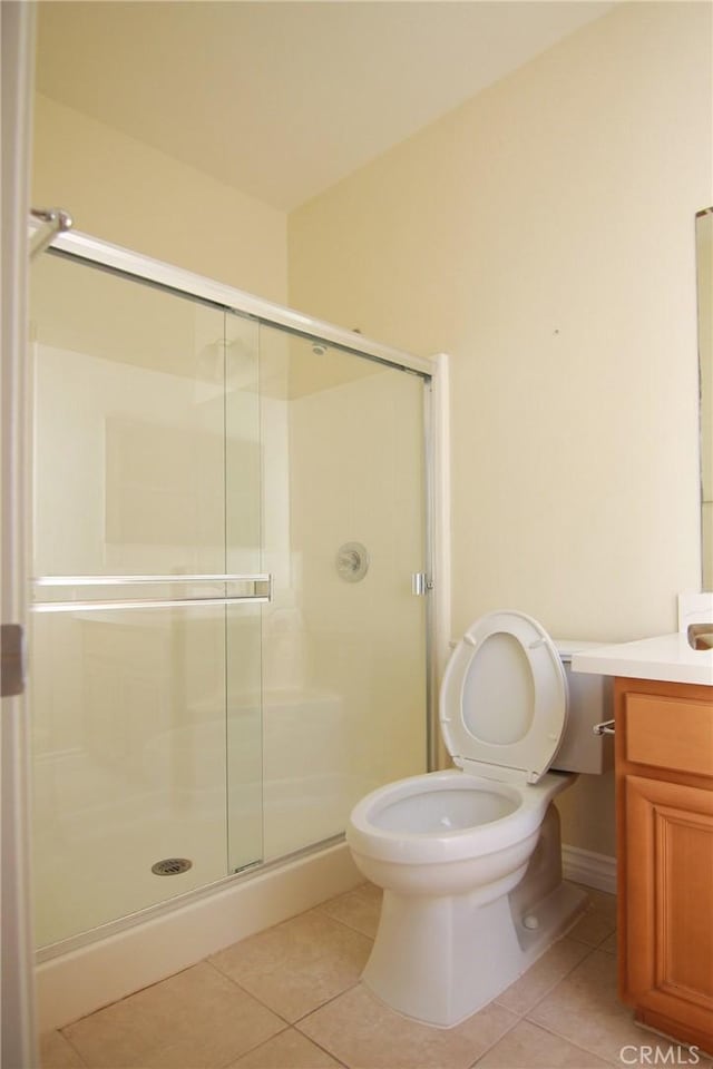 bathroom with tile patterned floors, toilet, an enclosed shower, and vanity