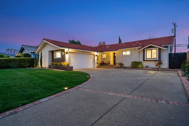 ranch-style house with a garage and a yard