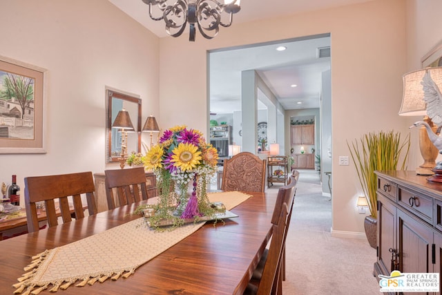 dining room with an inviting chandelier and light colored carpet