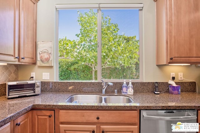 kitchen featuring plenty of natural light, sink, stainless steel dishwasher, and decorative backsplash