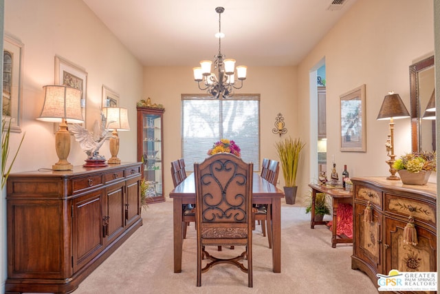 dining space featuring light carpet and an inviting chandelier