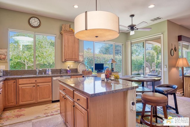 kitchen with sink, hanging light fixtures, plenty of natural light, a kitchen island, and stainless steel dishwasher