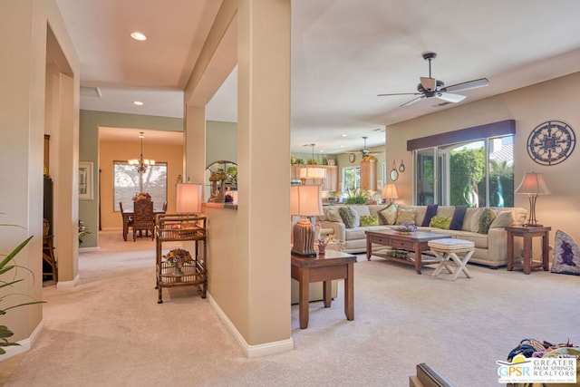 living room featuring light carpet and ceiling fan with notable chandelier