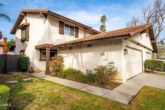 mediterranean / spanish home featuring a garage and a front yard