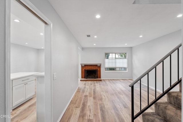 unfurnished living room featuring a fireplace and light hardwood / wood-style flooring