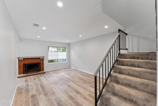 unfurnished living room with a fireplace and light wood-type flooring