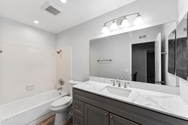 full bathroom featuring hardwood / wood-style flooring, vanity, toilet, and tiled shower / bath combo