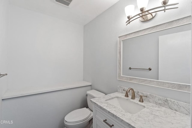 bathroom with vanity, a notable chandelier, and toilet