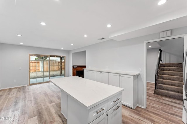 kitchen featuring white cabinetry, a kitchen island, and light hardwood / wood-style floors