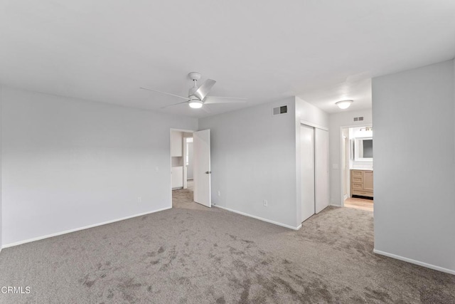 carpeted spare room with ceiling fan