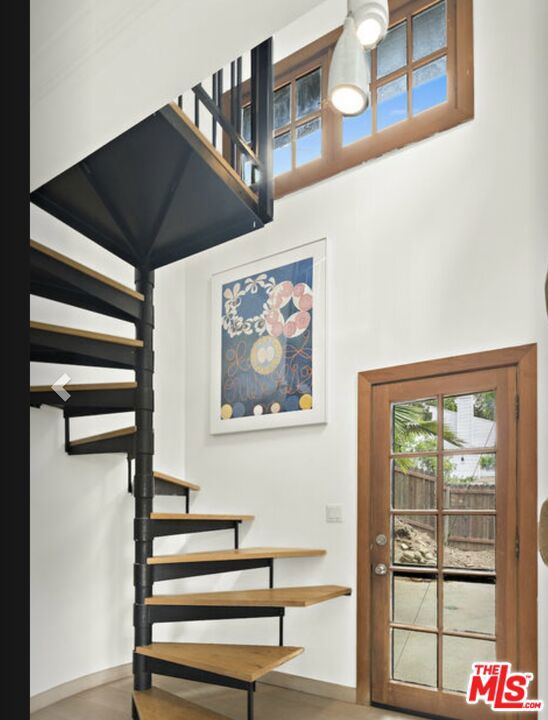 stairs featuring a high ceiling, ornamental molding, and hardwood / wood-style flooring