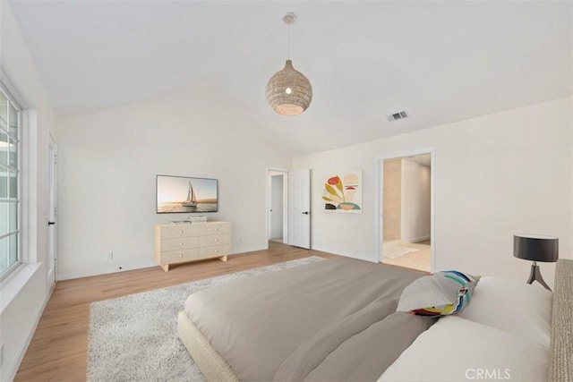 bedroom featuring multiple windows, vaulted ceiling, and light hardwood / wood-style floors