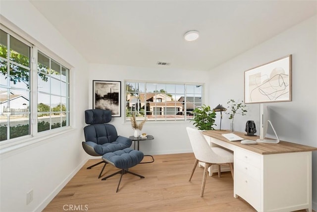 home office with light hardwood / wood-style flooring and plenty of natural light