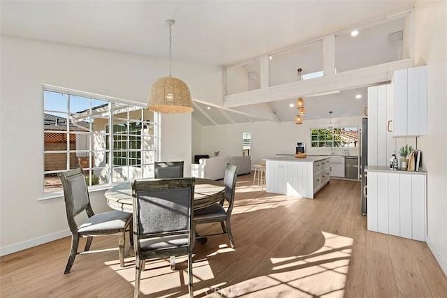 dining space with lofted ceiling and light hardwood / wood-style floors