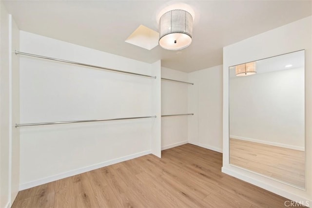 walk in closet with wood-type flooring