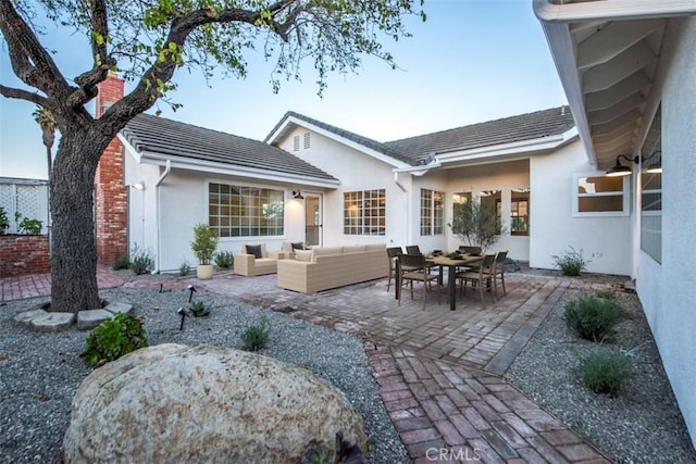 back of house with an outdoor living space and a patio area