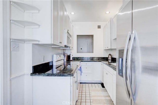 kitchen featuring white cabinetry, white appliances, dark stone countertops, and light tile patterned flooring