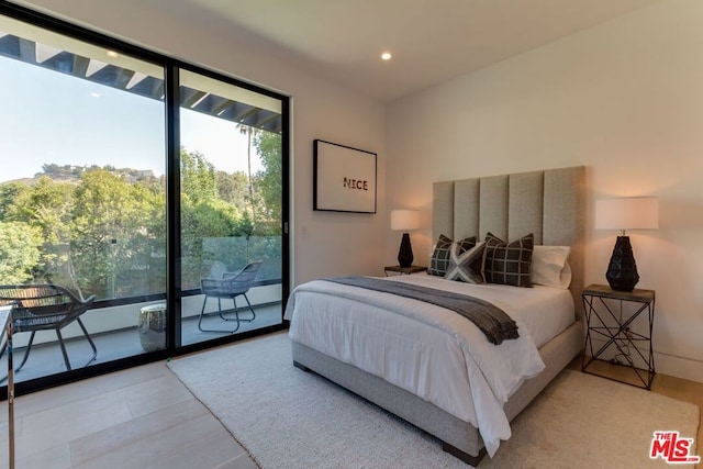 bedroom with wood-type flooring and access to outside