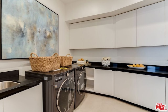 laundry room featuring washer and clothes dryer and cabinets