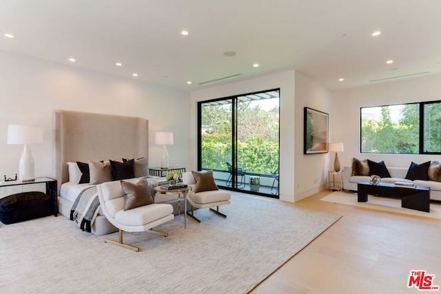 bedroom with access to exterior, multiple windows, and light wood-type flooring