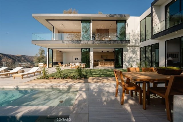 back of house with a mountain view and a patio