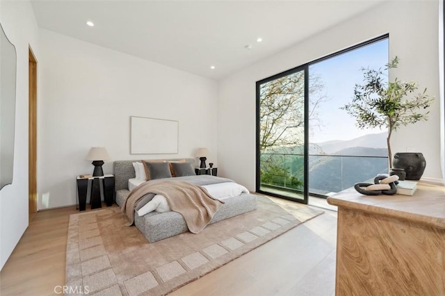 bedroom with a mountain view and light wood-type flooring