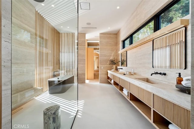 bathroom featuring vanity, concrete floors, and a bathing tub