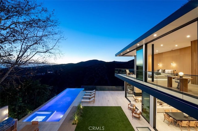 pool at dusk featuring a mountain view