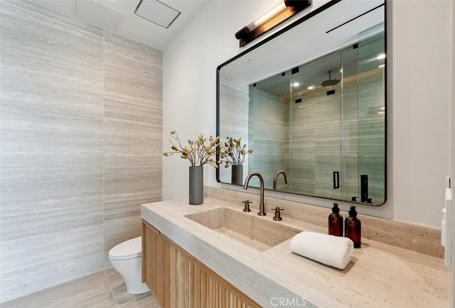 bathroom featuring vanity, toilet, tile patterned flooring, and tile walls