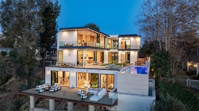 rear view of house with a patio area, outdoor lounge area, and a balcony