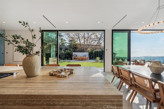 dining room with expansive windows and a water view