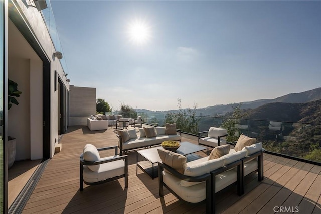 wooden deck featuring a mountain view and an outdoor hangout area