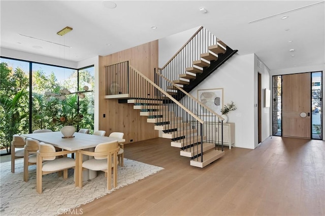 dining space featuring hardwood / wood-style floors and wood walls