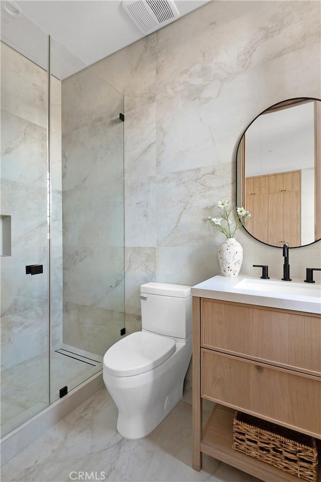 bathroom featuring vanity, toilet, tile walls, and a tile shower