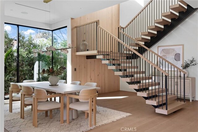 dining area with hardwood / wood-style floors and wood walls