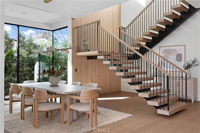 dining space with hardwood / wood-style flooring and wood walls