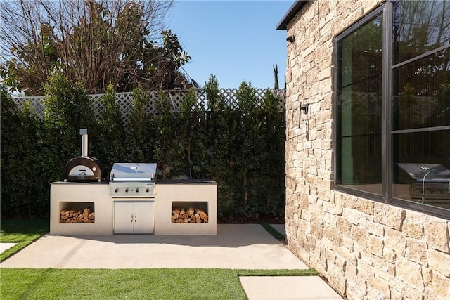 view of patio / terrace with exterior fireplace, grilling area, and an outdoor kitchen