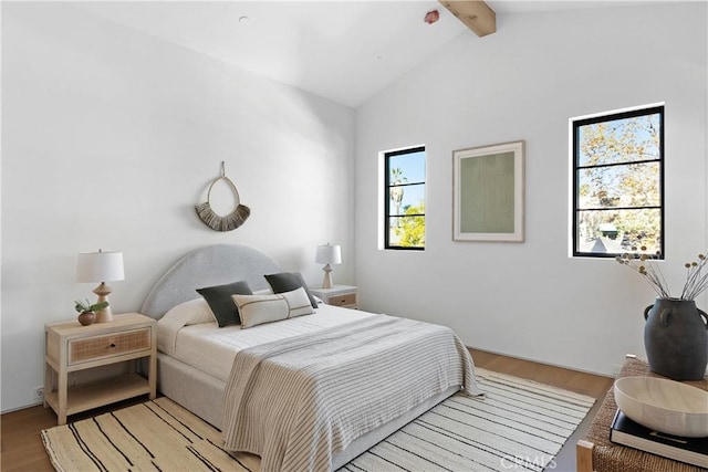 bedroom featuring lofted ceiling with beams and hardwood / wood-style floors