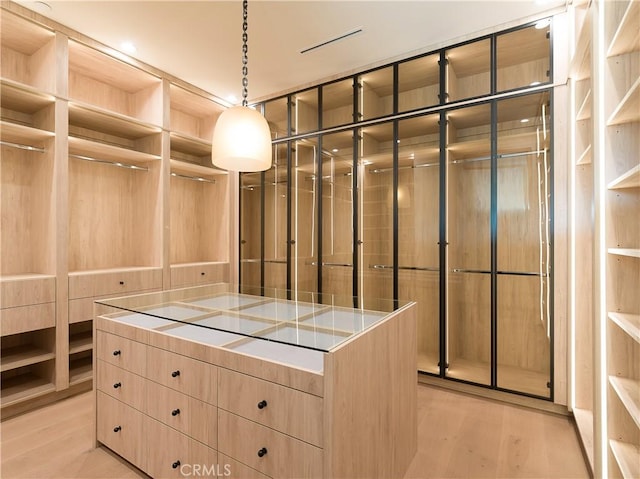 walk in closet with light wood-type flooring