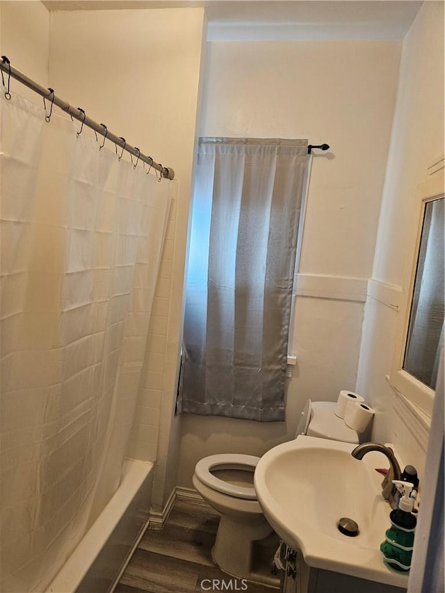 full bathroom featuring shower / bath combo, hardwood / wood-style floors, vanity, and toilet