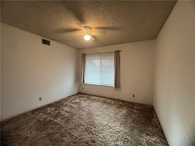 carpeted empty room with ceiling fan and a textured ceiling