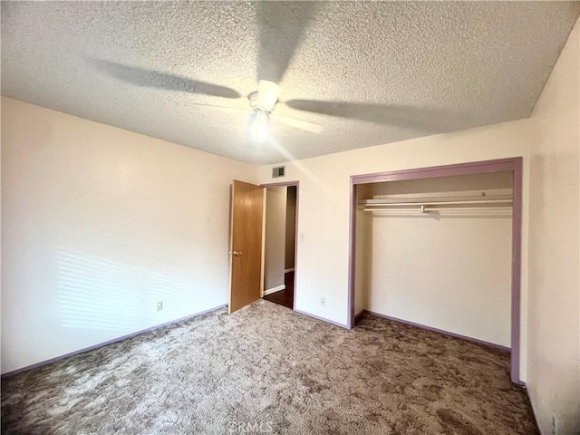 unfurnished bedroom with a textured ceiling, a closet, ceiling fan, and dark colored carpet