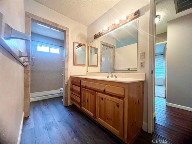 bathroom with wood-type flooring, toilet, a textured ceiling, and vanity