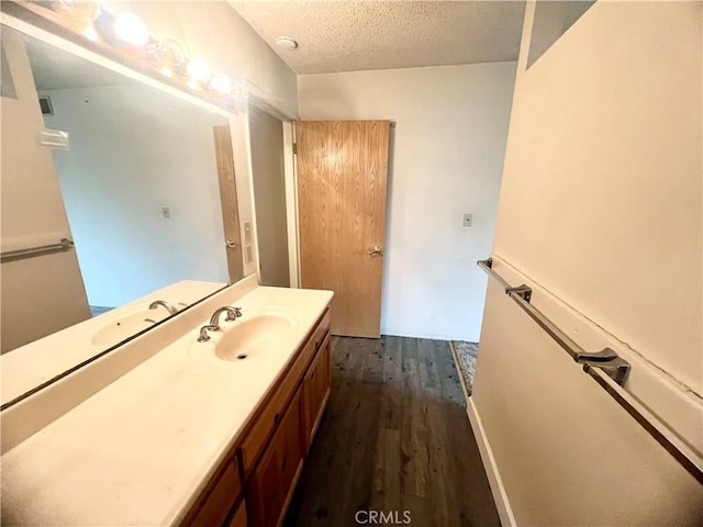 bathroom featuring vanity, hardwood / wood-style floors, and a textured ceiling