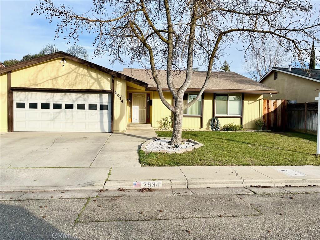 ranch-style home with a garage and a front lawn