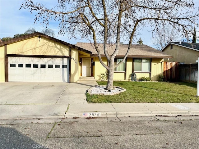 ranch-style home with a garage and a front lawn